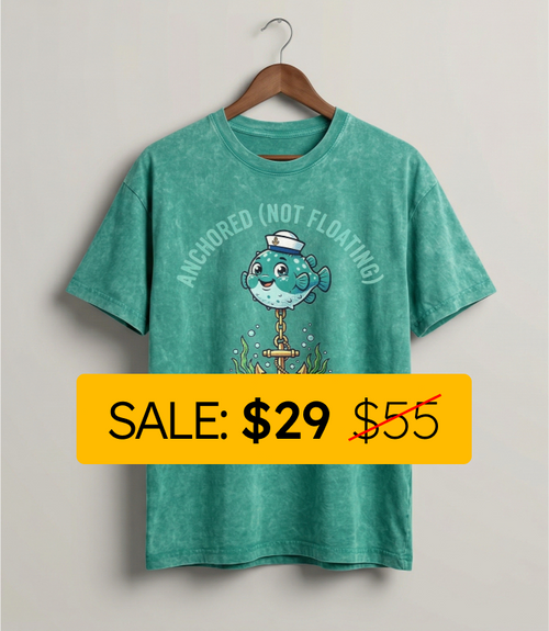 Green t-shirt with a cartoon fish design and sale label on a plain background